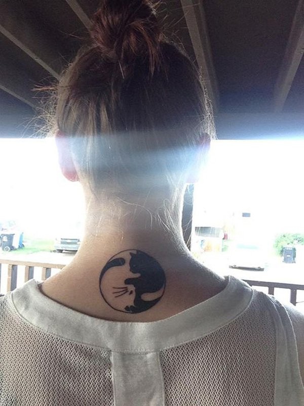 Curled black and white cat Asian Yin Yang symbol shaped tattoo on lady&quots upper back