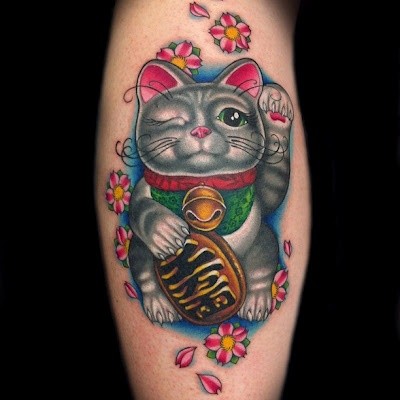 Cute and funny looking leg tattoo of colored maneki neko japanese lucky cat tattoo on leg