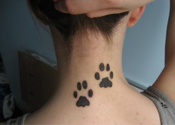 Nette Tierpfoten Tattoo am Hals in dunkler schwarzer Tinte