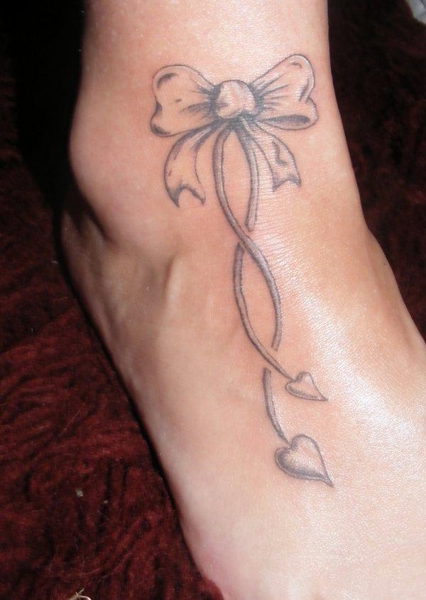carino fiocco con due cuori tatuaggio su piede