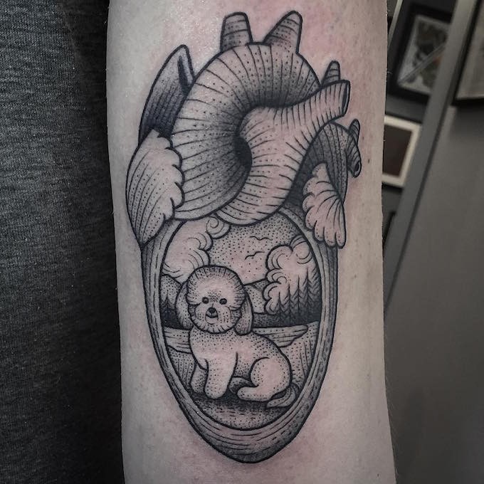 Cute black ink human heart tattoo on forearm stylized with tiny dog