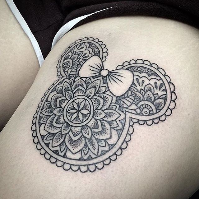 Cute black ink Minnie mouse shaped tattoo on thigh stylized with ornamental flowers