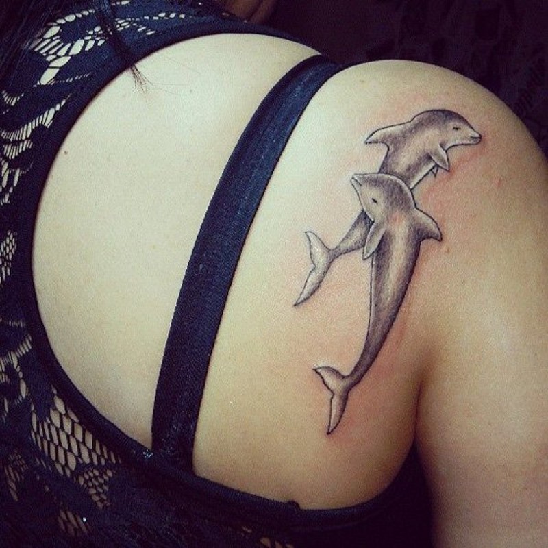 Cute cartoon like colored dolphins tattoo on shoulder