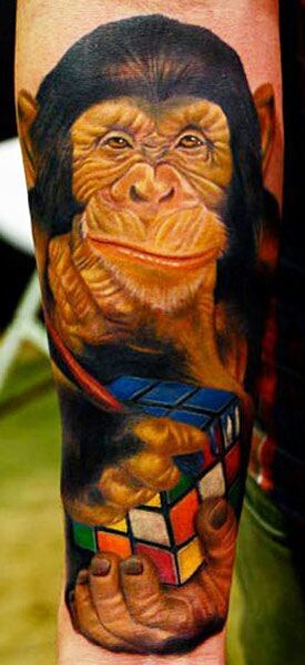 Tatuaje en el antebrazo,
chimpancé lindo y cubo de Rubik