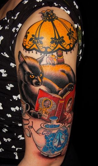 Tatuaje en el brazo, gato que lee un libro