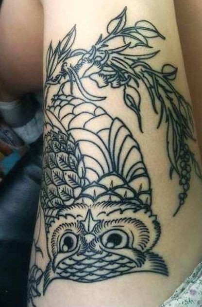 Nette detaillierte weise Eule sitzt auf einem Ast herrliches Tattoo am Mädchens Oberschenkel
