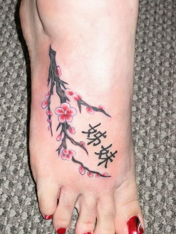 Süßes Tattoo von Kirschblüten und japanischen Hieroglyphen auf dem Fuß