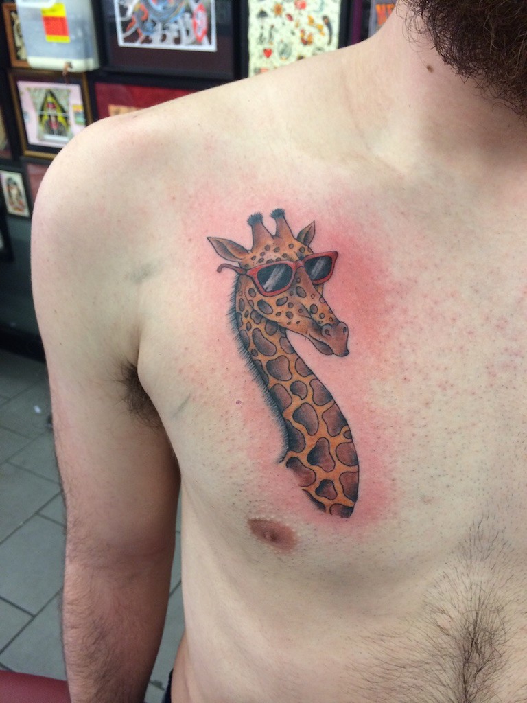 Tatuaje en el pecho, 
cabeza de jirafa en gafas