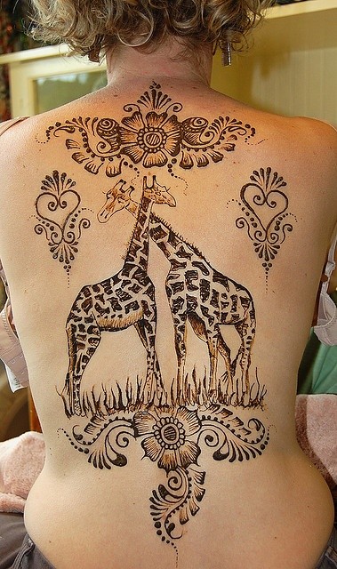 Cute giraffes with floral patterns tattoo on back