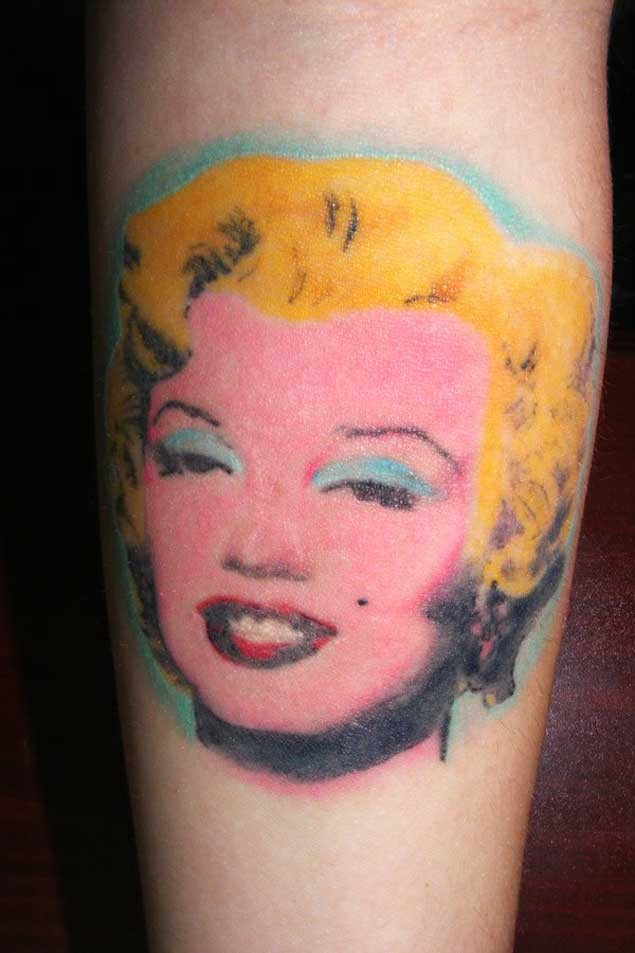 Cute homemade like colored Merlin Monroe portrait tattoo on forearm