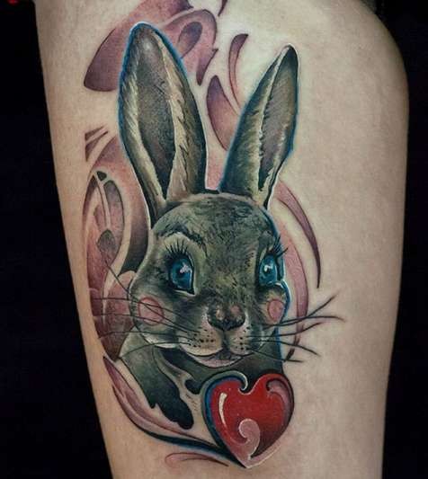 Cute illustrative style thigh tattoo of beautiful rabbit and red apple