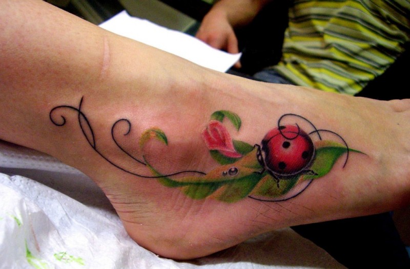 bella coccinella su foglie  tatuaggio su piede
