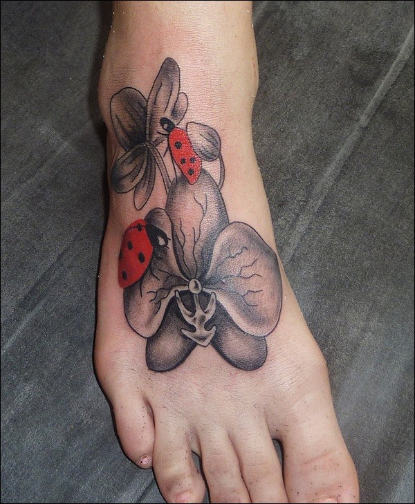 Tatuaje en el pie, dos mariquitas en flores grises