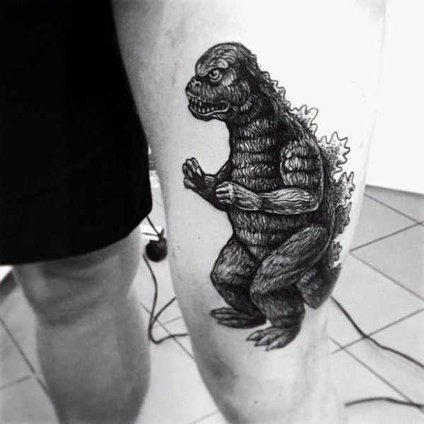 Netter kleiner schwarzer und weißer Godzilla Tattoo am Oberschenkel