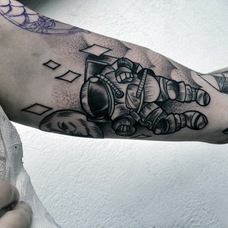 Cute little cartoon like astronaut tattoo on arm