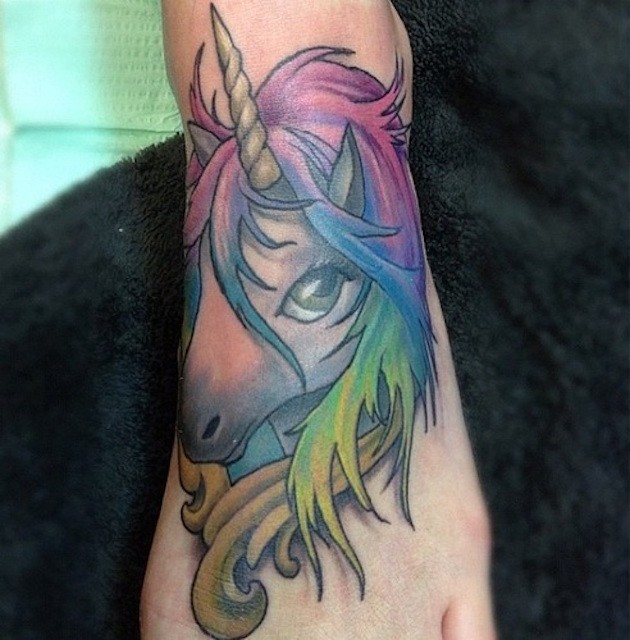 Cute little multicolored fantasy unicorn tattoo on foot