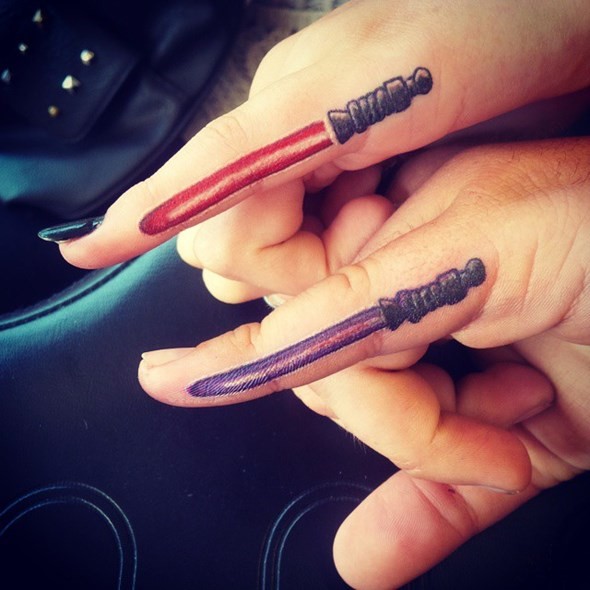 Tatuajes en los dedos, sables de luz rojo y púrpura