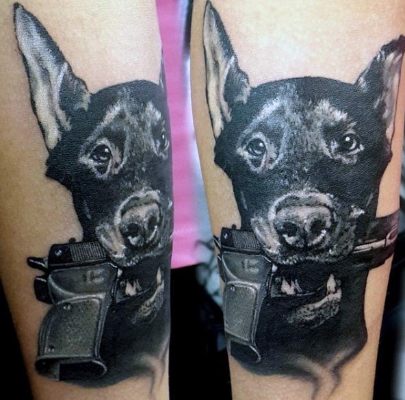 Cute looking colored forearm tattoo of dog with pistol in mouth