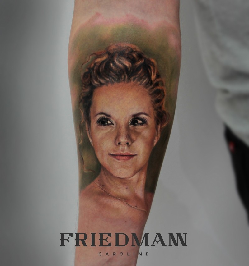 Cute looking colored woman portrait tattoo on forearm