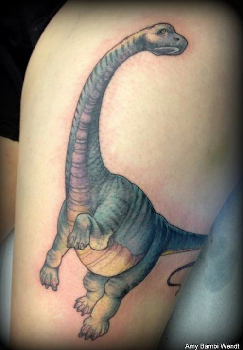 Cute looking illustrative style dinosaur tattoo on thigh