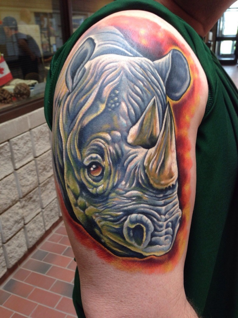 Tatuaje en el brazo, rinoceronte en el fondo rojo