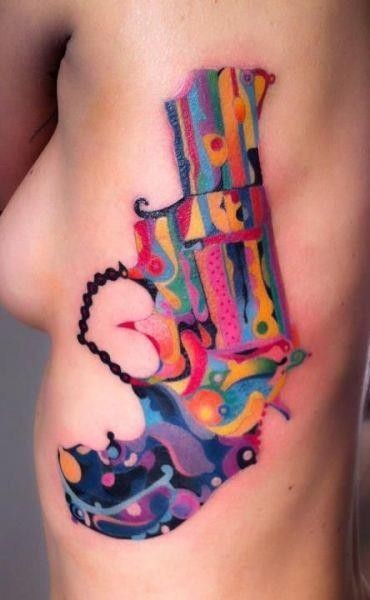 Tatuaje en el costado, pistola grande de varios colores