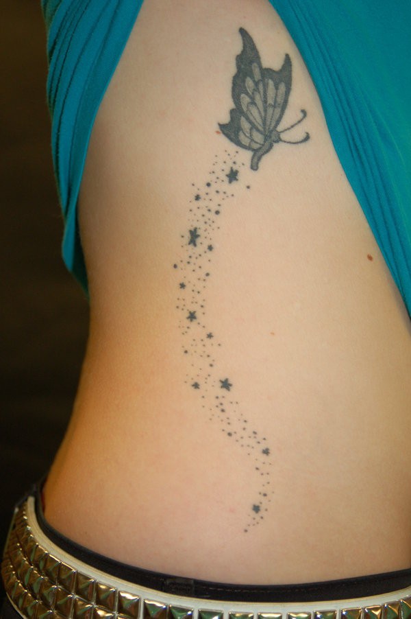 Tatuaje en el costado, mariposa  gris con estrellas