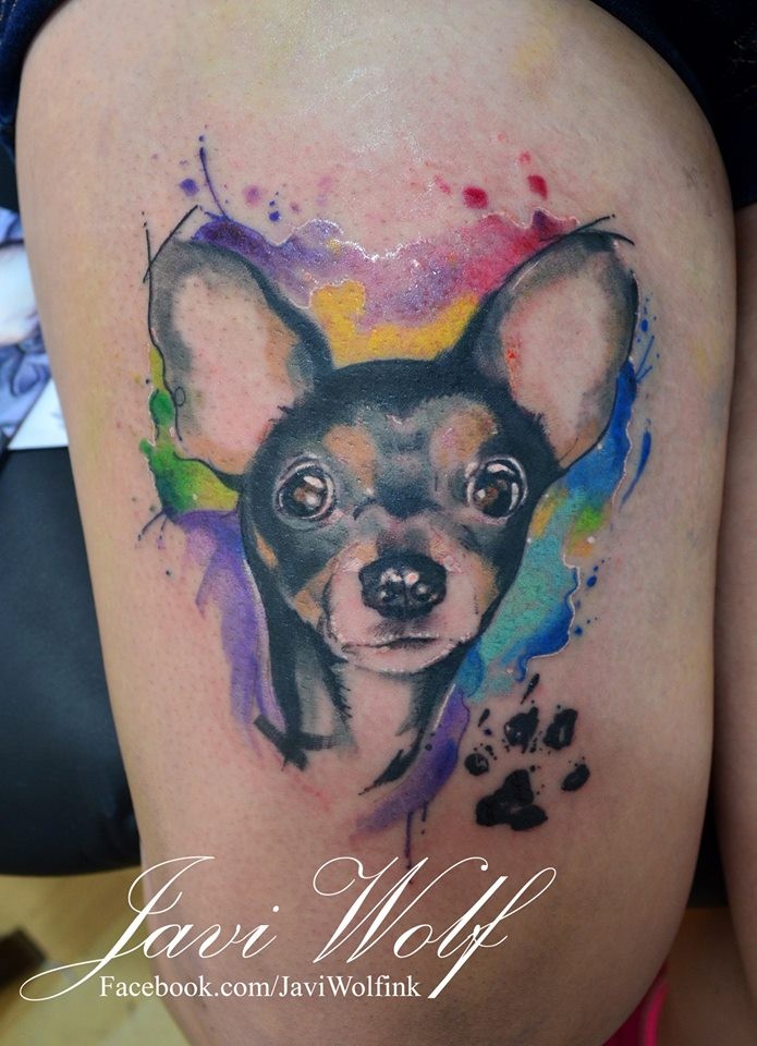 Nettes kleines Hundenporträt mit Pfotenabdruck Tattoo mit farbigen Farbetropfen im Aquarell Stil am Oberschenkel von Javi Wolf