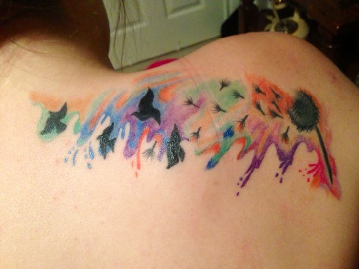 Dandelion and flock of black birds rainbow colored tattoo on shoulder blade in watercolor style
