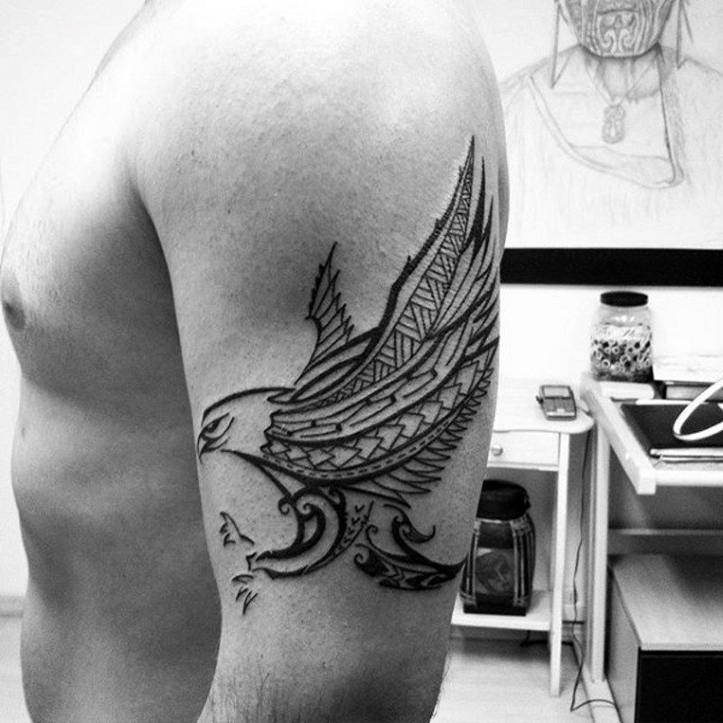 Dark black and white flying eagle tattoo on shoulder in tribal style