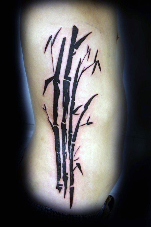 Dark black ink Asian oriental style bamboo tree tattoo on side