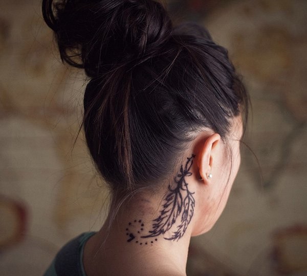 Tatuaje detrás de la oreja, plumas largas elegantes, tinta negra