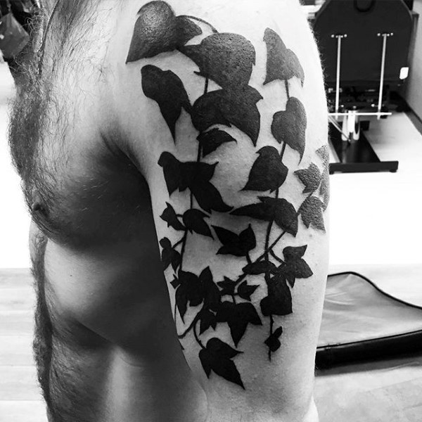 Dark black ink ivy with leaves tattoo on shoulder area of arm