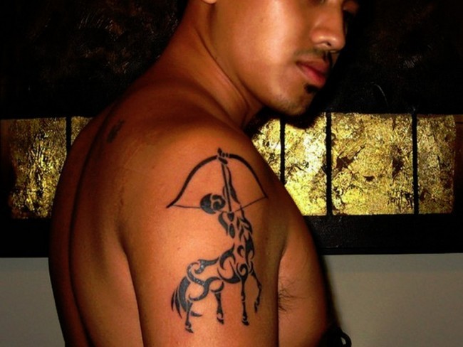 Dunkler schwarzer Schütze Tattoo auf der Schulter im Tribal Stil