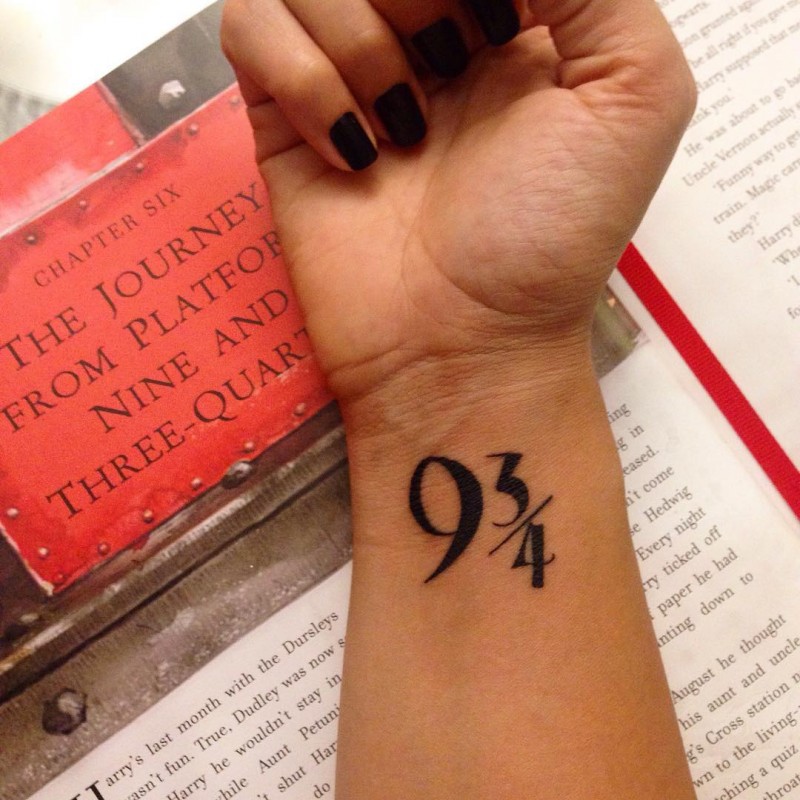 Dark black ink symbolic numbers 9 3/4 wrist tattoo