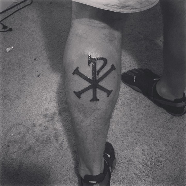 Dark black ink thick Christ monogram Chi Rho tattoo on leg