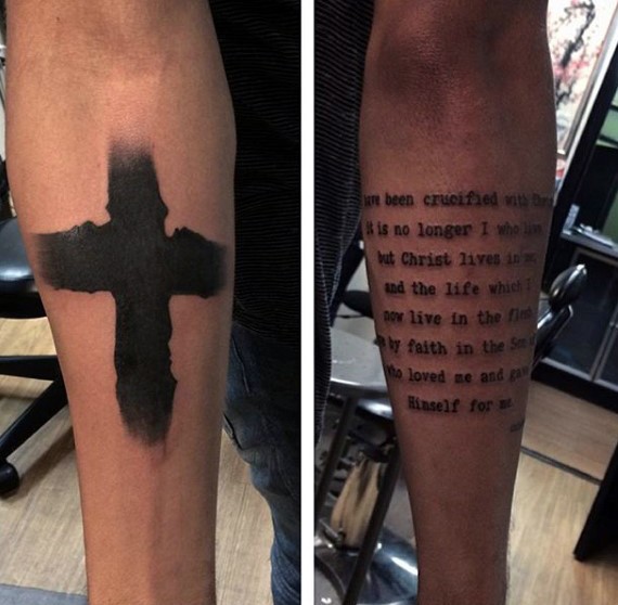 Dunkles schwarzes dickes Kreuz und religiöser Schriftzug Tattoo an beiden Unterarmen