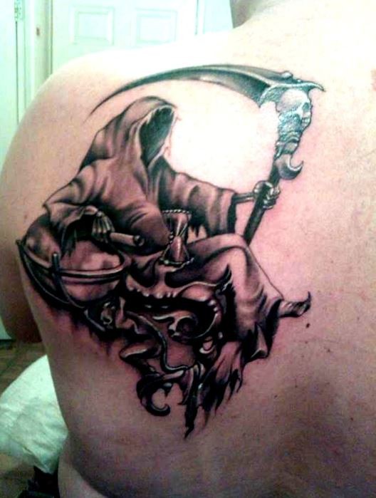 Death sitting on throne tattoo on shoulder blade