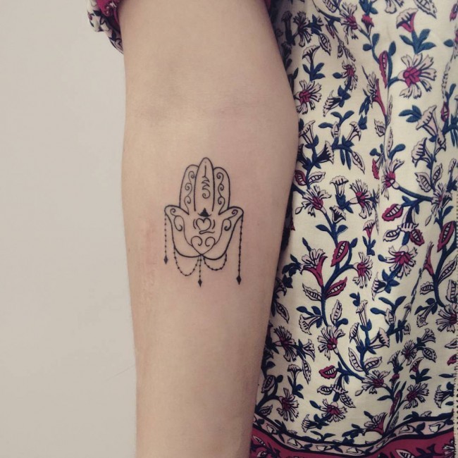 Empfindliches kleines schwarzweißes Hamsa Hand Tattoo am weiblichen Unterarm