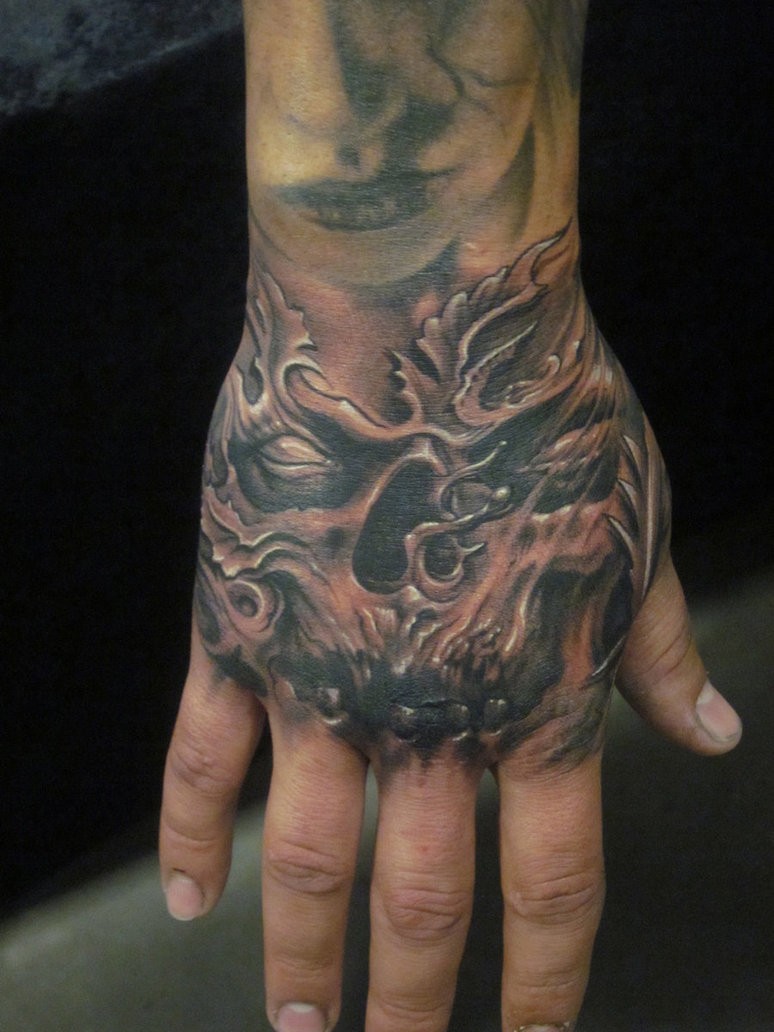 Tatuaje en la mano, cráneo con dientes negros