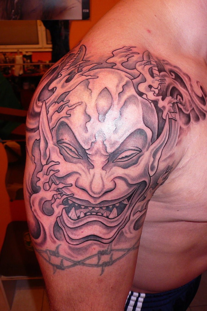 Tatuaje en el brazo, máscara de un demonio