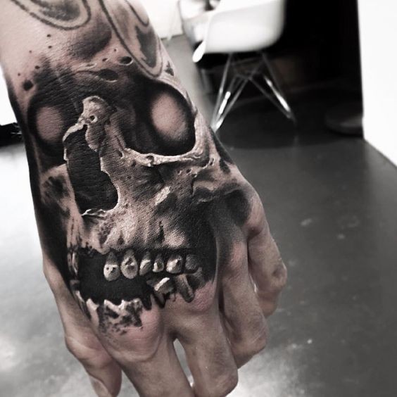 Tatuaje detallado de gran mano de cráneo humano