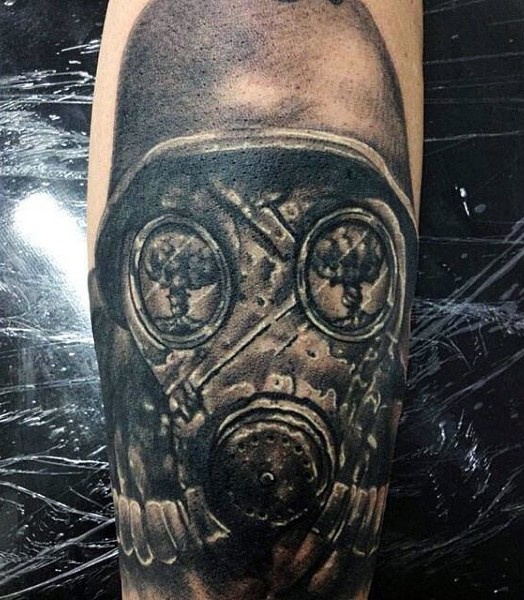 Detailed black ink forearm tattoo of broken gas mask