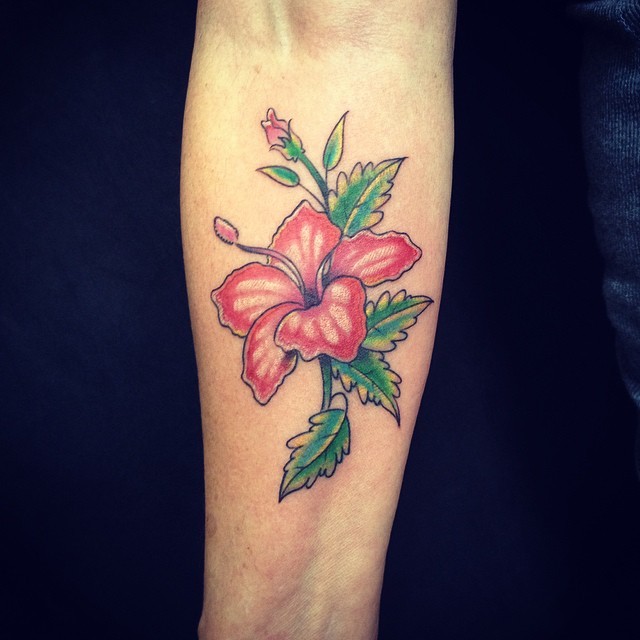 Detailed colored hibiscus flower tattoo on forearm in Hawaiian style