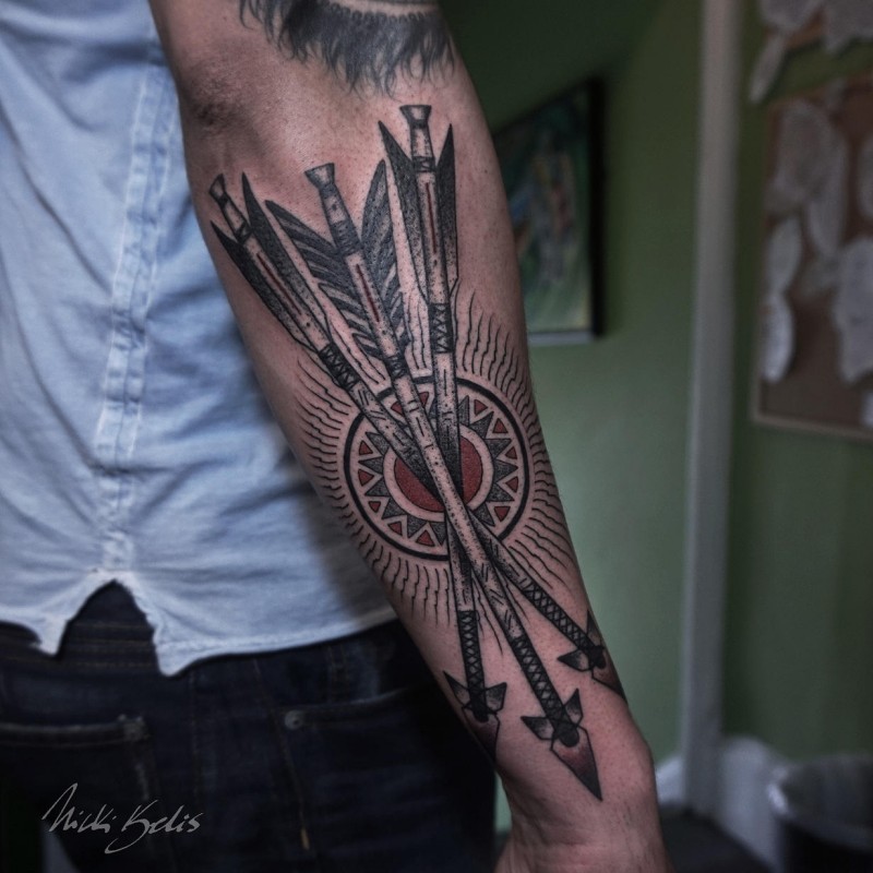 Detailed looking colored arm tattoo of crossed arrows with sun