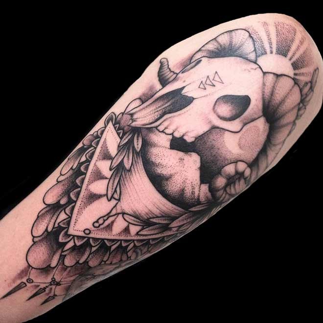 Dotwork style large shoulder tattoo of animal skull with various symbols