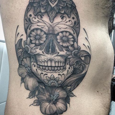 Dotwork style large side tattoo of Mexican traditional skull stylized with flowers