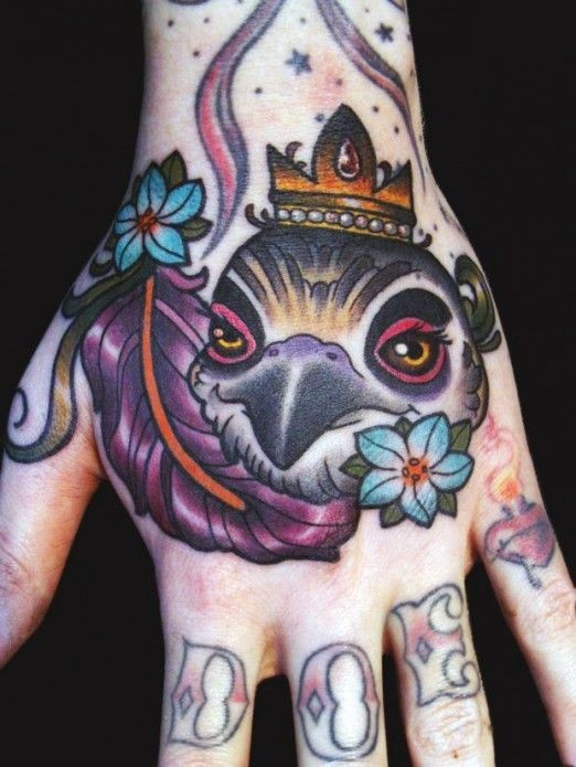 Tatuaggio colorato sulla mano la testa di colomba con la corona
