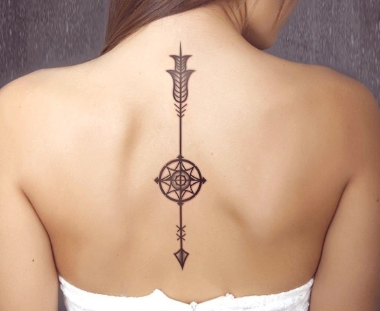 Tatuaje  de flecha con compás en la espina