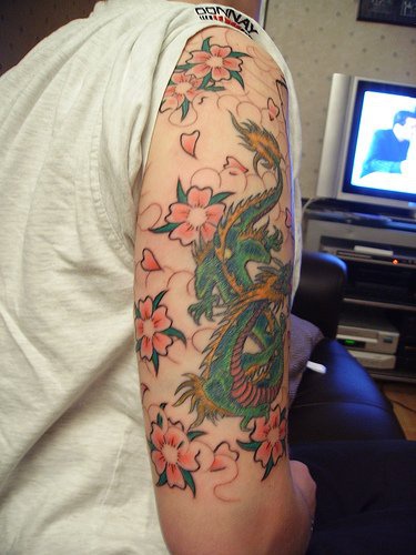 Dragon in sakura flowers tattoo